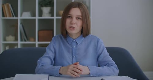 Woman Talking at Desk Indoors
