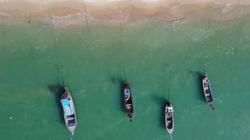 Aerial view from drones of fishing boats in the shore during low tide.