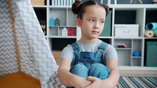 расстроенный ребенок сидит на полу