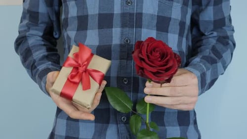 Man Holding Gift and Red Rose for Anniversary