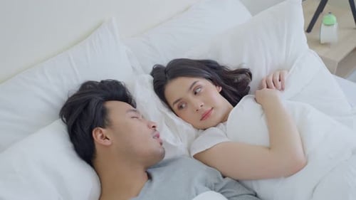 Une femme asiatique se sent frustrée par le fait que son mari ait une odeur terrible et une mauvaise haleine après le réveil le matin.
