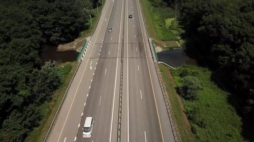 Top Down Close Up View of Highway Road Passing Through the Rural Countryside and Green Forest