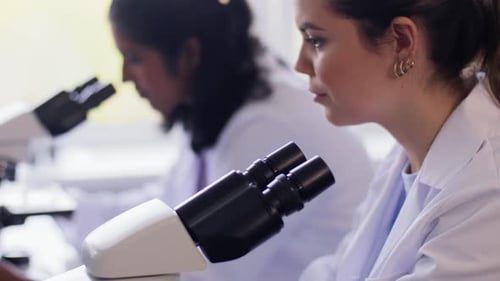 Científicos con microscopios trabajando en laboratorio