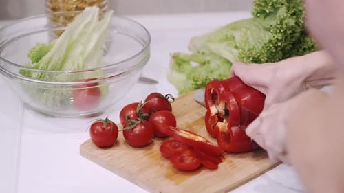 Close Up of Female Hand Cutting Pepper on Board in Kitchen Room