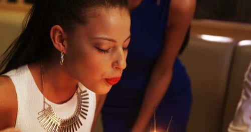 Friends celebrating birthday with cake and sparklers