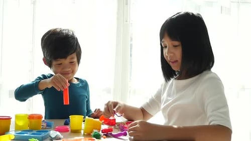 Children Play with Modeling Clay at Bright Table