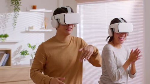 Enthusiastic Couple Enjoys Virtual Reality Gaming at Home