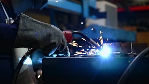 Ein Schweißer arbeitet daran, Metall zu schweißen. Um qualitativ hochwertige Arbeit gemäß der vorgeschriebenen Form zu erstellen