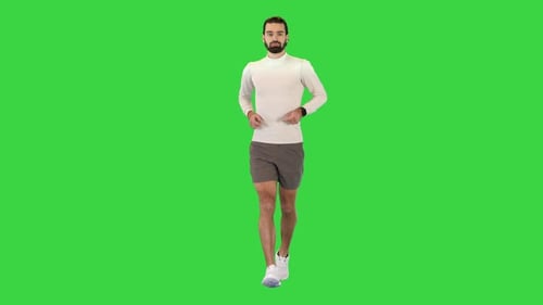 Corredor masculino bonito e confiante correndo em uma tela verde Chroma Key