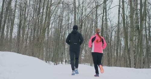 A Beautiful Woman and a Man Are Running in the Forest in Winter Proper Nutrition and a Healthy