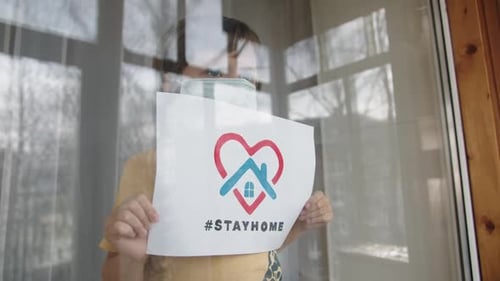 Child Holding Stay Home Sign with Face Mask