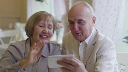 Senior Couple Waving During a Video Call