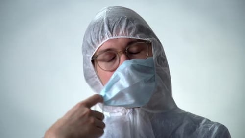 Person in Protective Suit Removing Face Mask