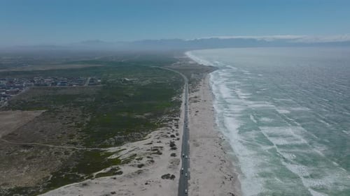 Aerial Panoramic Footage of Coastal Landscape with Cars Driving on Road and Mountains in Distance