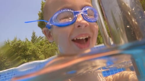 Child wearing goggles diving in the pool