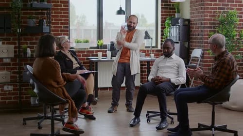 Adults Clapping After Man Speaks at Meeting