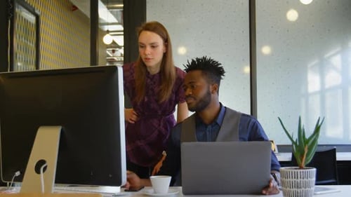 Front view of young cool mixed-race business team planning and working at desk in a modern office 4k