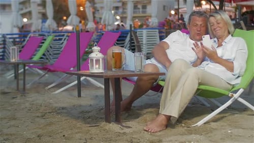 Casal com smartphone na espreguiçadeira