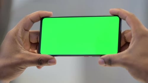 Holding Smartphone with Green Chroma Key Screen
