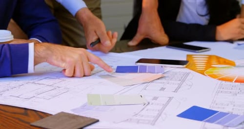 Executives discussing over blueprint in conference room at office 4k