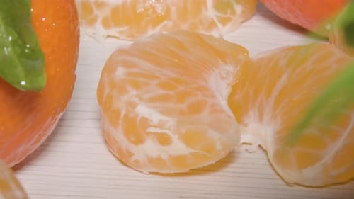 Makroaufnahme aus nächster Nähe, die 2 Segmente einer Mandarinorange auf einem Tisch zeigt, ein frisches, gesundes Zitrusfell