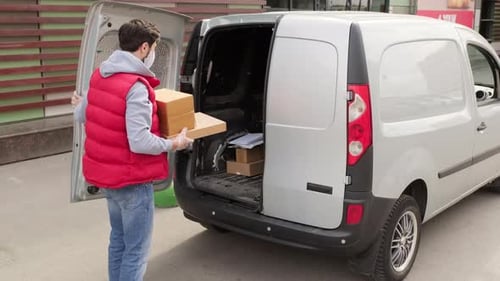 Courier in Face Mask Loading Packages into Van