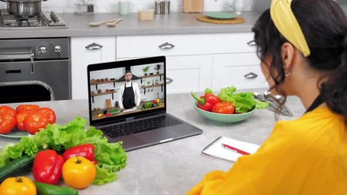 Woman Attending Virtual Cooking Class in Bright Kitchen