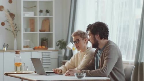 Couple Discussing Something on Laptop Screen at Home