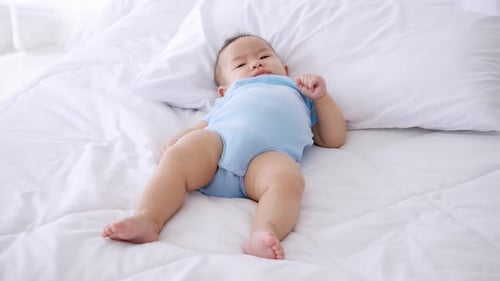 Adorável bebezinho deitado na cama.
