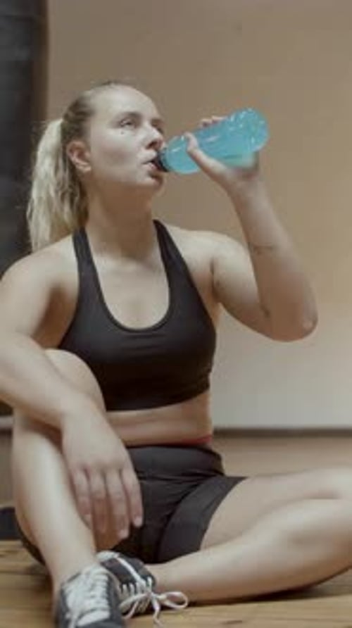 Front View of Female Athlete Drinking Isotonic After Workout