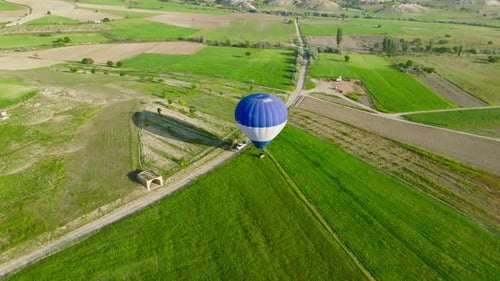 Hot air balloons fly over the mountainous landscape of Cappadocia, Turkey.