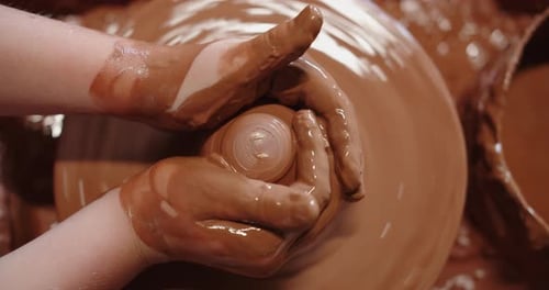 Close Up of Hands Shaping Clay on Pottery Wheel