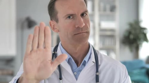 Stop Gesture By Senior Doctor in Clinic