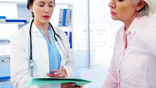 Female Doctor Consults with Senior Patient in Office