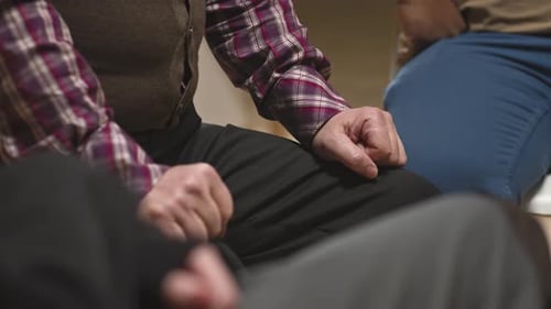 Elderly Person Sitting with Hands on Lap