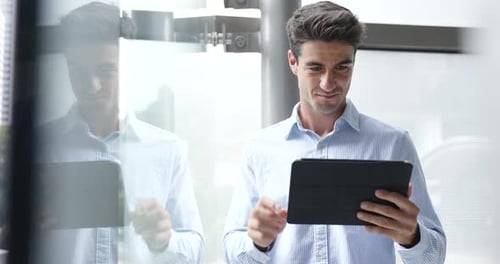 Smiling Man Using Tablet in Office Setting