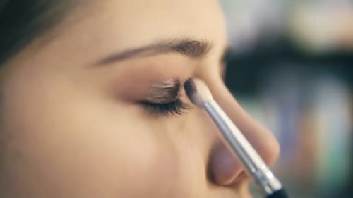 Closeup View of Professional Makeup Artist Hands Using Makeup Brush to Apply Eye Shadows
