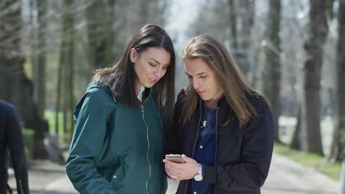 Young Adults Using Cellphone in Urban Park