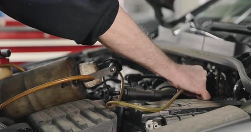Mechanic Repairing Car Engine in Garage
