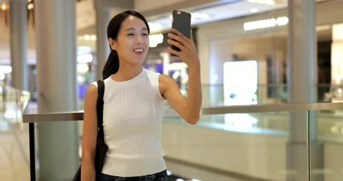 Femme utilisant un téléphone intelligent avec des sacs à provisions