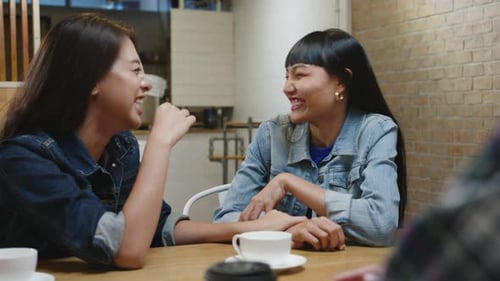 Group of happy young Asian friends having fun a great time and laughing enjoying meal at cafe.