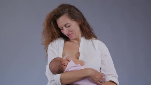 Loving Mother Breastfeeding Newborn Infant in Close Up