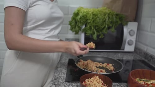 Woman Cooking and Tasting Food in Kitchen