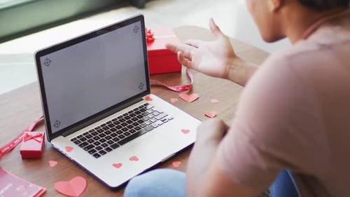 Young Adult Video Chatting on Laptop with Gifts