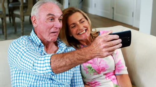 Senior Couple Taking Selfie Together on Couch