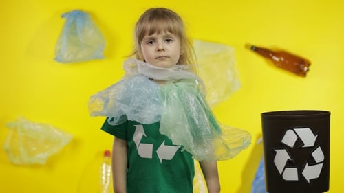 Niña activista se libera de paquetes de plástico en el cuello y la cabeza. Contaminación plástica. Salva la ecología
