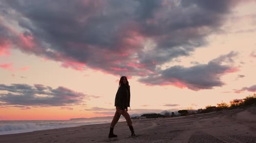 Girl dance on the beach at sunset