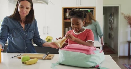 Family Packing Lunch in Kitchen for School Child