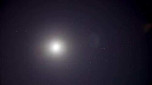 Zeitraffer: hell leuchtender Mond und Sterne am Nachthimmel 4K