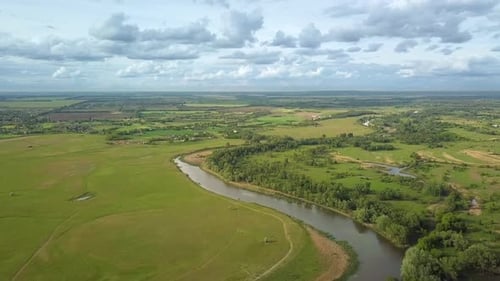 Flight Over Green Meadow and River in Spring
